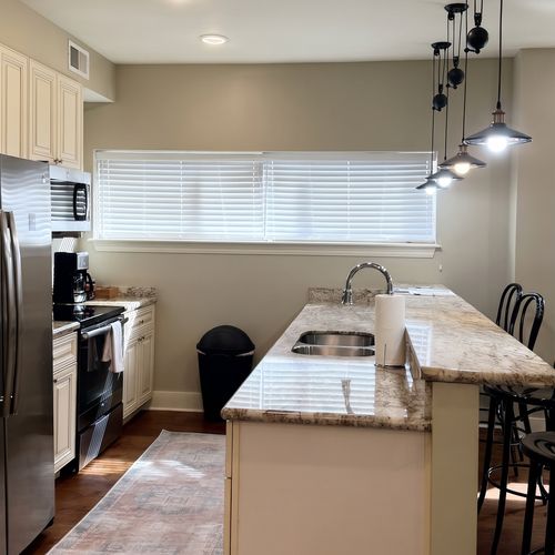 Kitchen w/ granite counters & double sink, open to the living space