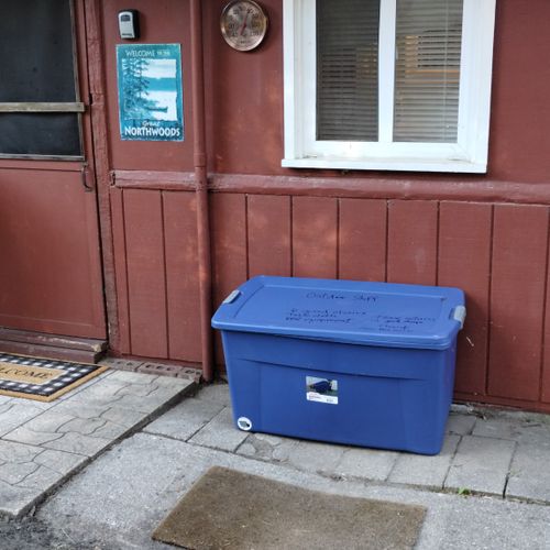 EXTERIOR:  Bin containing outdoor chairs, tools for grilling, and roasting sticks