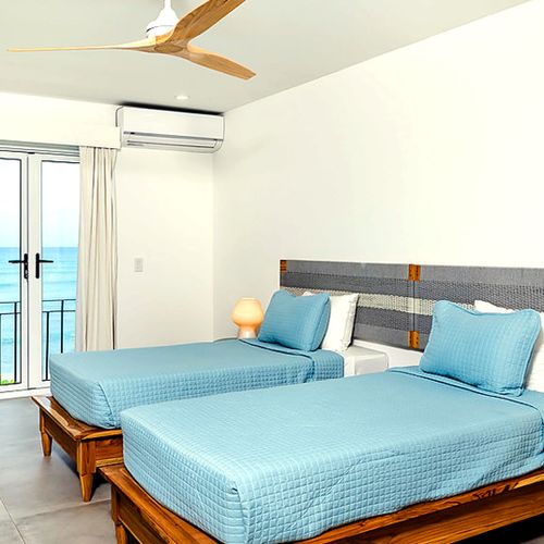 Twin bed guest room opening to the terrace and pacific views