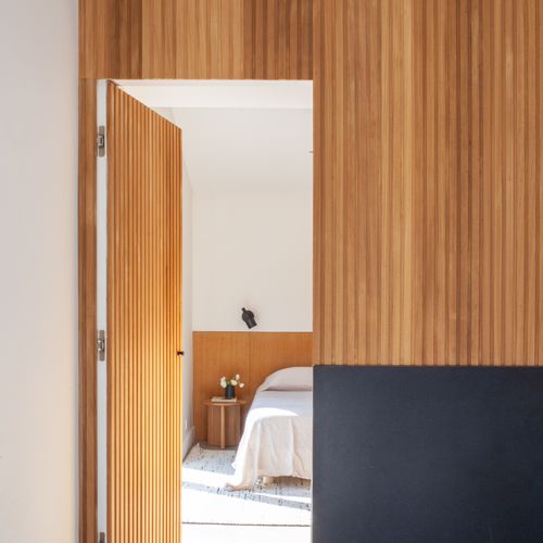 Warm wood-slatted corridor leading to the bedrooms.