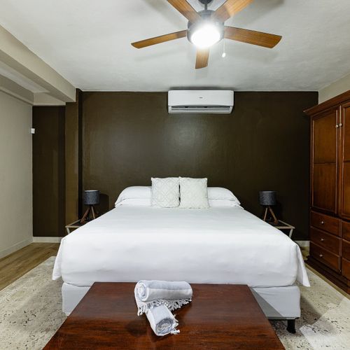 Casita king bedroom - moody olive walls, coastal-style decor, the quiet corner of the estate.