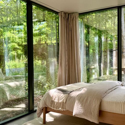 A cozy, upscale sanctuary featuring a plush queen bed and unparalleled, panoramic woodland views.