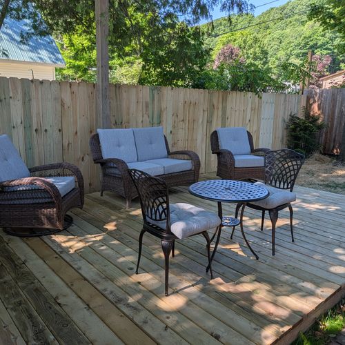 OVERVIEW: The cute fenced-in backyard of the apartment furnished with outdoor seating for a relaxing time