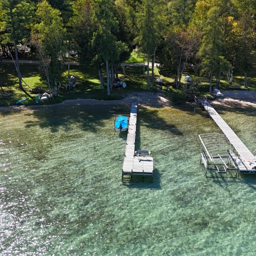 OVERVIEW:  Aerial view of the private dock, beach, bonfire ring, kayaks, and paddleboards.