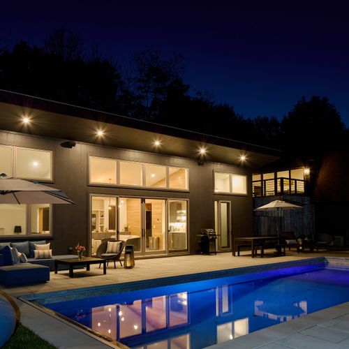 The pool house in the evening, with the second story guest house just beyond.