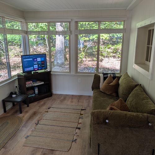 OVERVIEW:  The sunroom, with a sofa and a streaming television