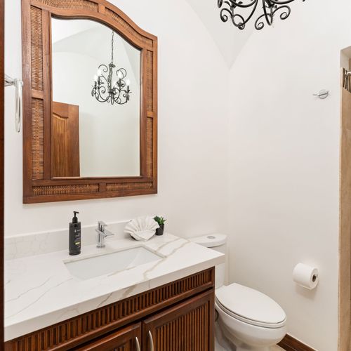 Elegant guest bathroom vanity with single sink, coastal decor, and stylish finishes at Playa Langosta condo in Tamarindo, Costa Rica. Bright natural light, serene color palette, tranquil atmosphere for relaxing getaways.