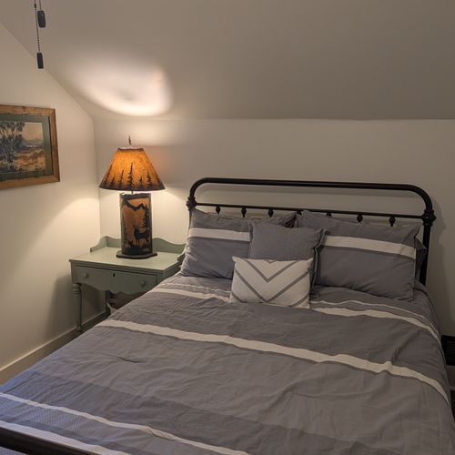 BEDROOM #2 (SECOND FLOOR):  Features a queen-size bed, nightstand, lamp, dresser, mirror, closet, and ceiling fan.