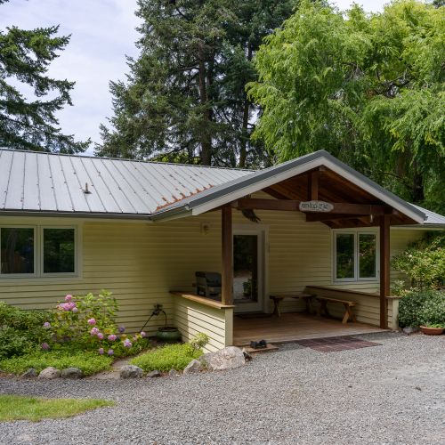 Welcome to North Beach Cottage, a charming island retreat with a covered front porch, lush landscaping, and peaceful surroundings—perfect for a relaxing getaway.