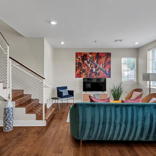 Teal sofa, red art, and a striking staircase
