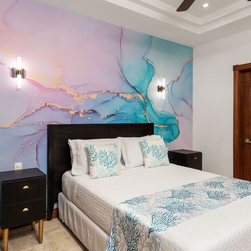Elegant guest bedroom with queen size bed, full wood closet, and coastal decor at a luxury Playa Langosta condo in Tamarindo, Costa Rica. Natural light, stylish furnishings, and serene atmosphere ideal for family vacations, beachfront stays.