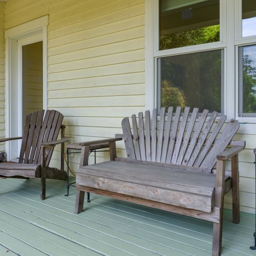 Unwind on the covered front porch with Adirondack seating, the perfect spot to enjoy your morning coffee or relax in the peaceful surroundings.