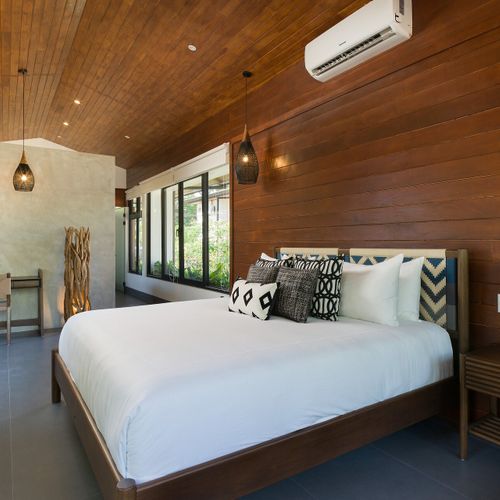 King bedroom suite at Casa Oso with hardwood walls, vaulted ceiling and adjoining workspace nook in Tamarindo, Costa Rica.