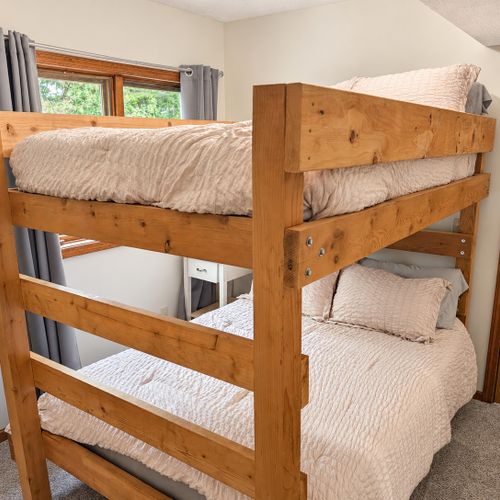 BEDROOM #2 (FIRST FLOOR):  Features a twin-on-twin bunk bed, nightstand, closet, dresser, and mirror.