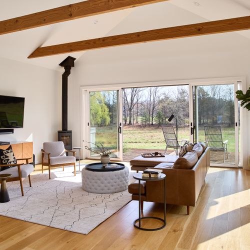 The living room in the main house features a functional wood stove, and sliding glass doors that open onto the hot tub deck.
