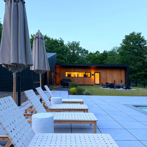 Settle into the loungers as twilight sets in and the home glows warm behind you.