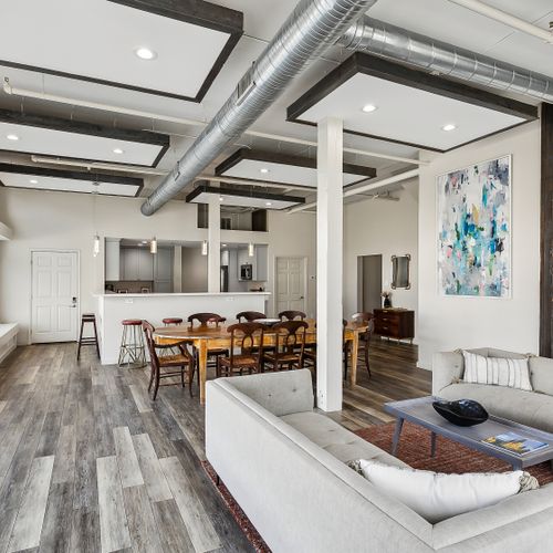 Open living & dining space w/ exposed beams & abstract art accent.