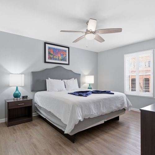 Serene primary bedroom w/ a king bed & crisp white linens for a restful night's sleep.
