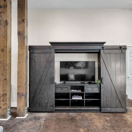 Barn door media cabinet with a Smart TV