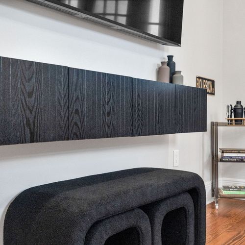 Settle in for movie night by the wall-mounted TV w/ a sleek wood-grain console & cozy curved seating