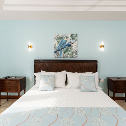 King size bed master suite with elegant coastal decor and luxury linens at Playa Langosta condo in Tamarindo, Costa Rica. Bright natural light, serene color palette, stylish furnishings, perfect for romantic escapes and peaceful privacy.