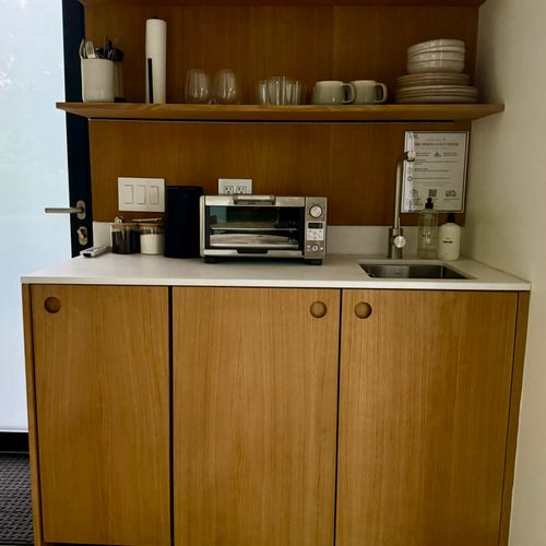 The guest house kitchenette, compact and fully appointed in white oak.