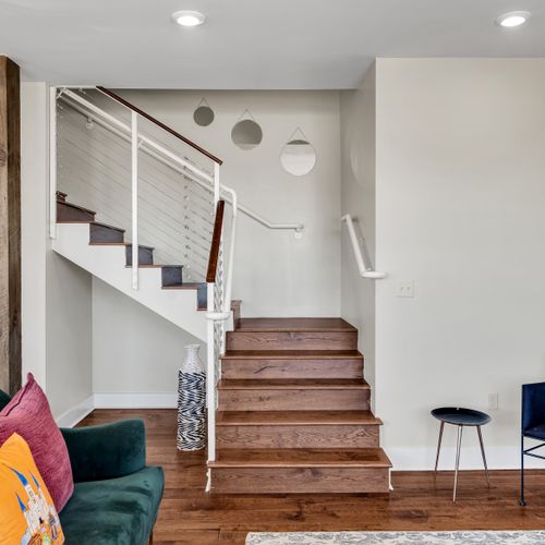 Staircase view down to the art-filled living area