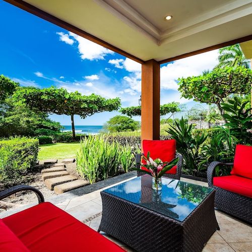 Luxury beachfront condo in Playa Langosta, Tamarindo, Costa Rica. Private ocean view balcony with outdoor seating, tropical gardens, infinity edge pool, and direct beach access. Steps from surf, restaurants, shops, and premium vacation rental condo.