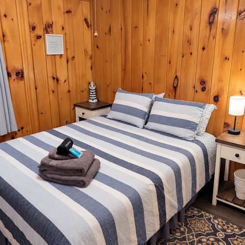 BEDROOM #2:   Features a queen-size bed, nightstands, lamp, dresser, closet, and chair.