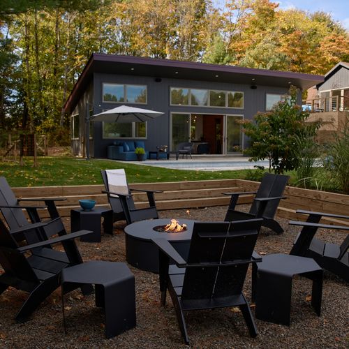 The propane fire pit, with pool deck and pool house in the background.