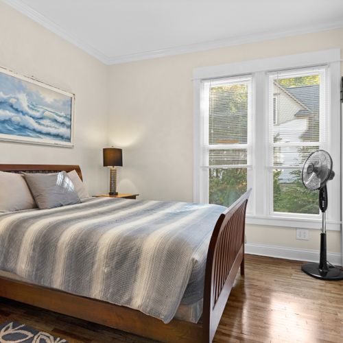 BEDROOM #1 (MAIN FLOOR) - HOUSE: Features a queen-size bed and its own private en suite full bathroom, dresser, nightstand, and closet