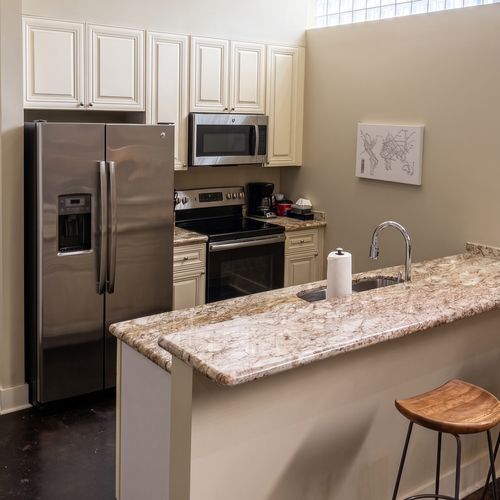Sleek kitchen w/ granite counters & stainless steel appliances