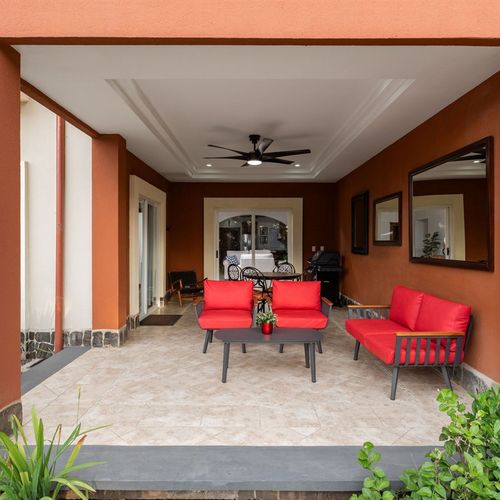Spacious balcony outdoor living area connected to the resort at luxury Playa Langosta condo in Tamarindo, Costa Rica. Comfortable seating, lush tropical gardens, ocean breeze, steps from pool, beach, and resort amenities for total relaxation.