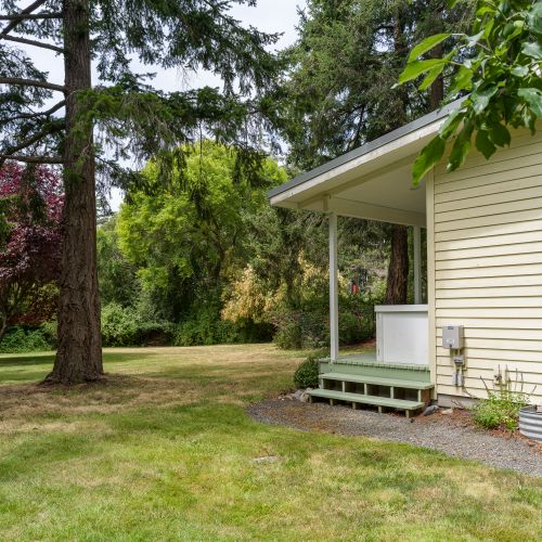 Enjoy a spacious backyard surrounded by mature trees, with plenty of room to relax, play, or gather outdoors in a peaceful island setting.