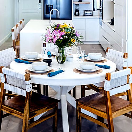 Round breakfast table beneath rattan pendant lights at Mar Azul, Playa Langosta, Tamarindo.