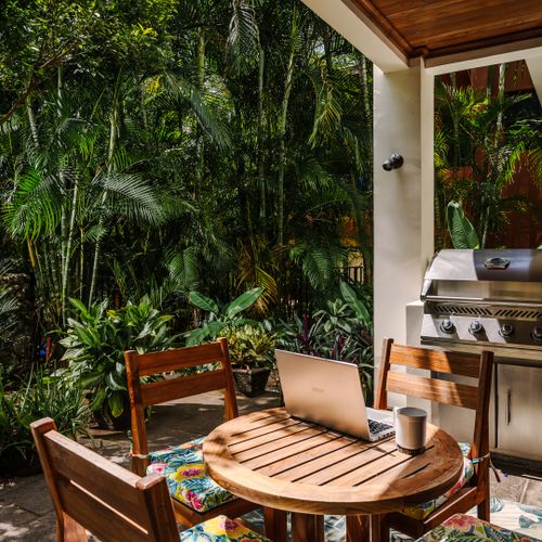 Remote work paradise on side terrace, overlooking lush garden at this Tamarindo vacation rental with pool. Fresh air, tropical nature, with Wi-Fi, and peaceful ambiance for digital nomads and work-from-home travelers in Langosta beach surf spot.