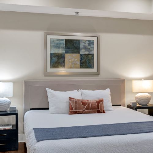 Framed geometric art above a plush bed