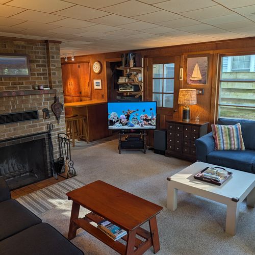 MAIN LIVING ROOM (FIRST FLOOR):  The home has a large, cozy, and comfortable living room on the main floor.  Note that the wood fireplace is available for guest usage.
