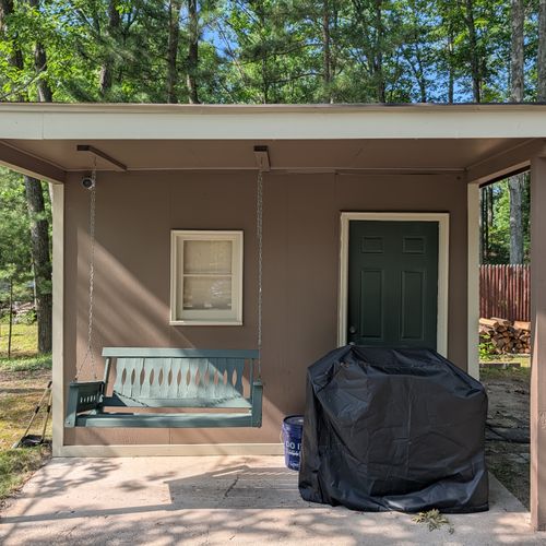 EXTERIOR:  The patio at the end of the driveway, with a swing and a propane grill.