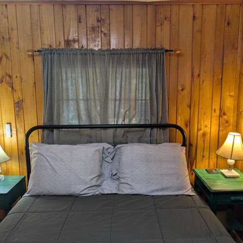 BEDROOM #1:  Includes a queen-size bed, nightstands, lamps, a dresser, and a mirror.