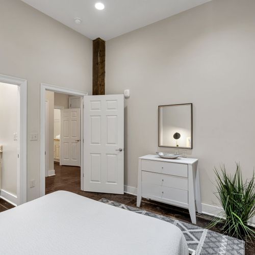 Bright bedroom with a white dresser and plants