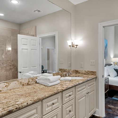 Bright vanity with a view of the bedroom