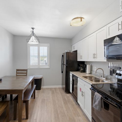 Unit 305 – Bright kitchen w/ modern appliances & a dining spot for the group.