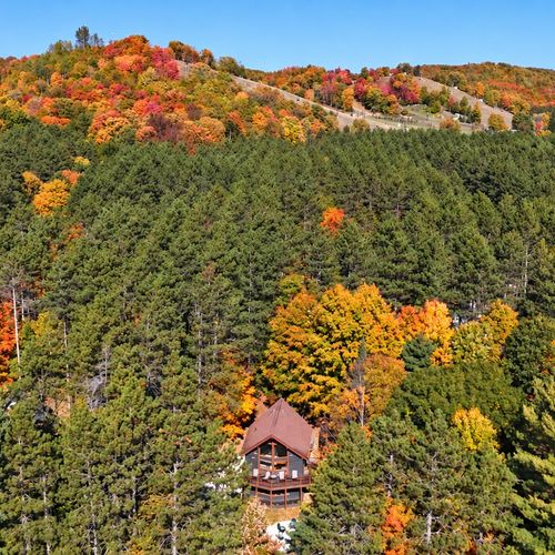 EXTERIOR:  Another aerial photo of the cabin in the Fall with Crystal Mountain Resort in the background.