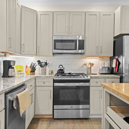 KITCHEN - HOUSE: The house has a newly-renovated kitchen with a large kitchen island and all appliances, including a dishwasher. There is also a good supply of cooking and dining utensils provided