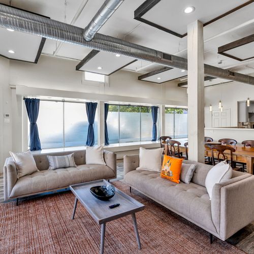 Sunlit lounge with soaring windows and exposed beams