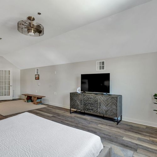 Upstairs bedroom with TV and cozy rug