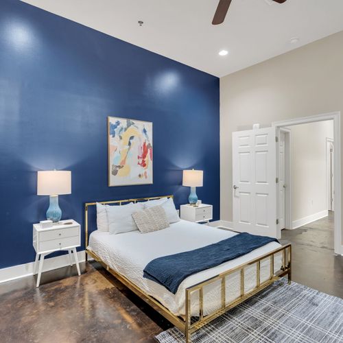 Brass bed and modern art against deep navy