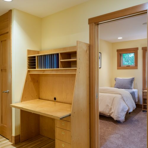 A built-in desk with shelving provides a practical spot to catch up on emails, plan your day, or work remotely, conveniently located between the bedrooms.