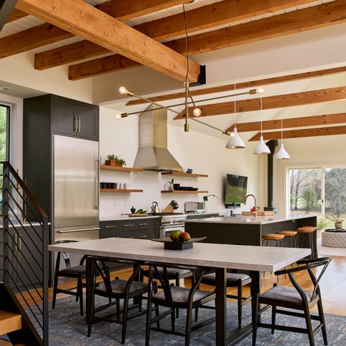 The chef's kitchen and dining area in the main house, with the living room and entry to the hot tub deck beyond.